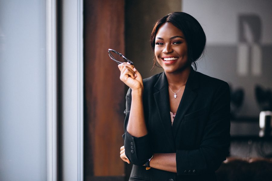5 Financial tips for women in 2021, Lifestyle Inflation, African american business woman by the window, Things to accomplish during COVID-19 lockdown