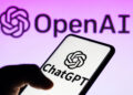 Smartphone displaying ChatGPT app with OpenAI logo on a purple background.