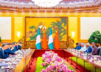 China-Nigeria diplomatic meeting with flags and officials seated.