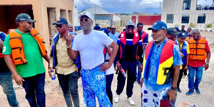 Group of people in life jackets inspecting a construction site during an outdoor dredging activity.